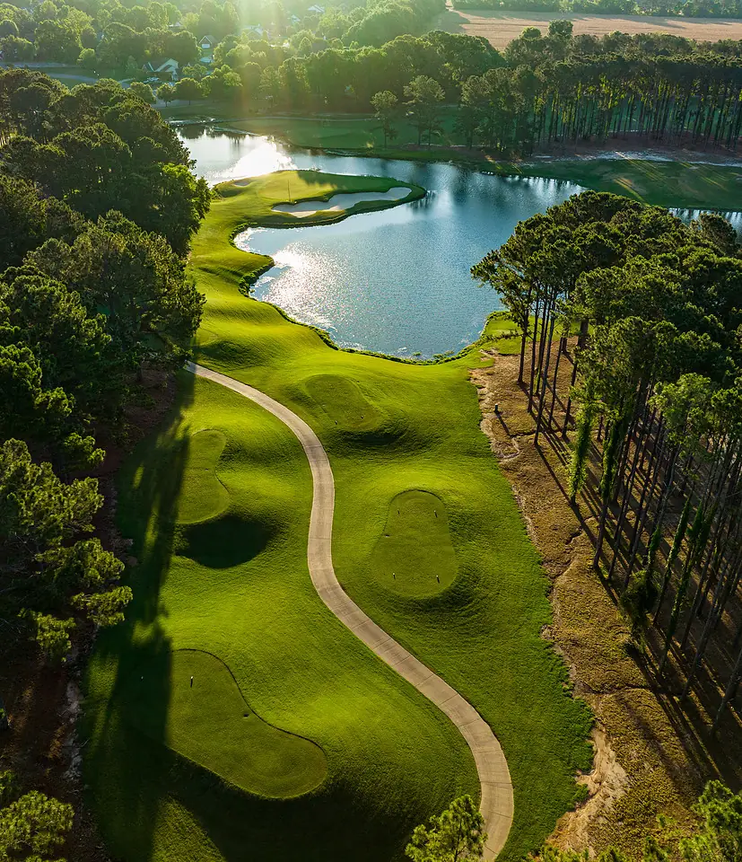 Drone shot of a fairway winding along a lake